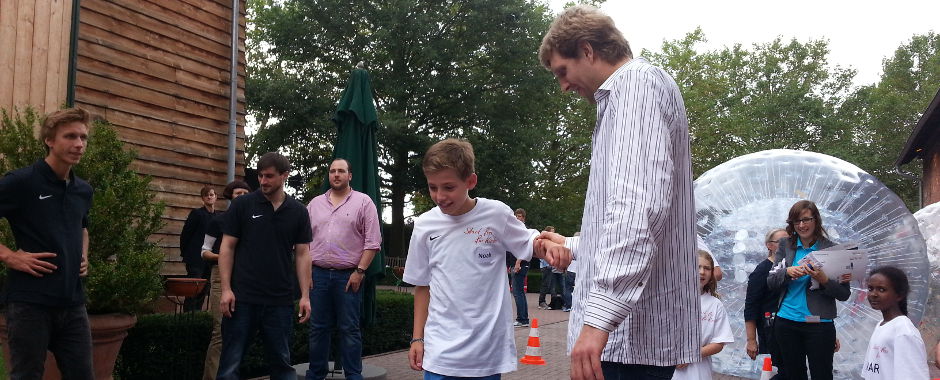 Basketballer Dirk Nowitzki zusammen mit einem teilnehmenden Kind von der Initiative BasKIDball.
