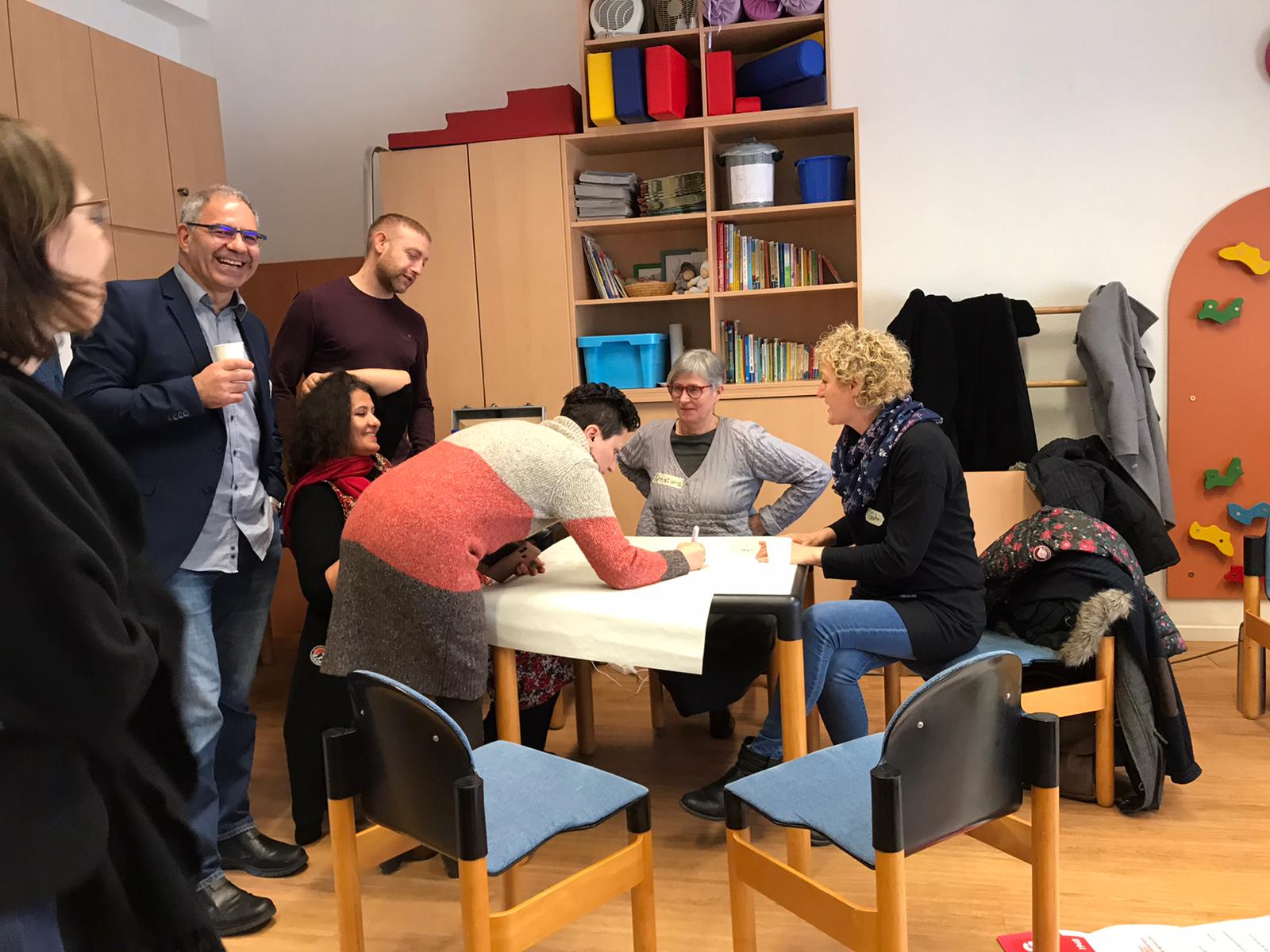 Teilnehmer des Trainernetzwerktreffen erarbeiten ein Plakat.